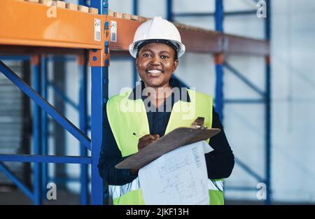 Leading by example for other women out there. an attractive young contractor standing in the warehouse and holding a clipboard. Stock Photo