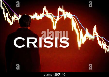 CRISIS word with the blurry background of the back view of a businessman looking despair at a red down-trending graph. Stock Photo