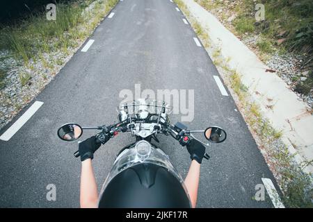 Biker girl on a motorcycle on summer forest road. Travel and sport, speed and freedom concept. Stock Photo