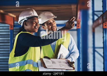 What about this. two young contractors standing together and examining the scaffolding in the warehouse. Stock Photo