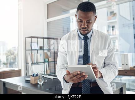 Anything is possible when you stay focused. a young doctor using a digital tablet in an office. Stock Photo
