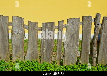Unusual wooden fence with parallel horizontal rails and vertical posts ...