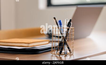 Make sure your pens are easy to find. Still life shot of a pen holder full of pens on a desk in an office. Stock Photo