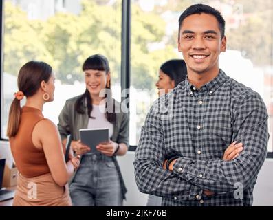 Im on stage, got a M in my minimum wage. Portrait of a young businessman at the office standing in front of his colleagues having a meeting in the Stock Photo