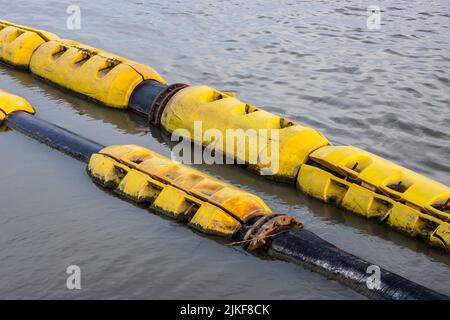 Floating old dredging pipes on the river close up Stock Photo