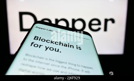 Smartphone with webpage of Canadian blockchain company Dapper Labs Inc. on screen in front of business logo. Focus on top-left of phone display. Stock Photo