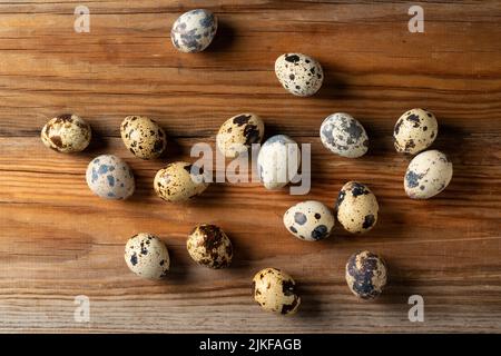 Many quail eggs placed against a wooden background. View from above Stock Photo