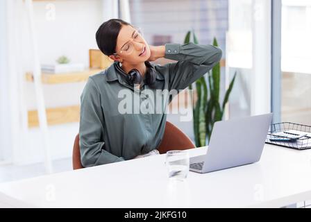 In desperate need of a massage. a businesswoman working in a call center experiencing neck pain. Stock Photo