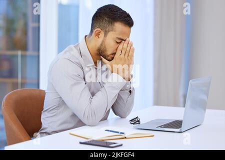 I cant afford anymore mistakes. a businessman looking stressed while sitting at his desk. Stock Photo