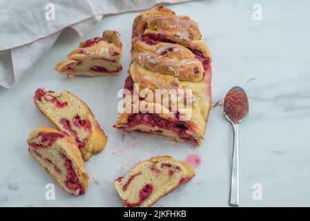 Sweet home made saffron raspberry babka on a table Stock Photo