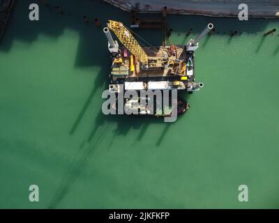 Floating crane dredging barges working on the construction of a marina. Aerial top view Stock Photo