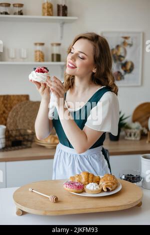Housewife holding a cake in her hands while standing in the kitchen Stock Photo