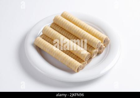 Sweet chocolate waffle rolls in plate on white background Stock Photo