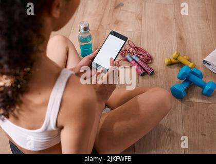 An over the shoulder shot of fitness app post work-out - chroma key Stock Photo