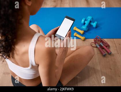 An over the shoulder shot of fitness app post work-out - chroma key Stock Photo