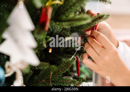Photo of white girl's hands decorating christmas tree at home Stock Photo
