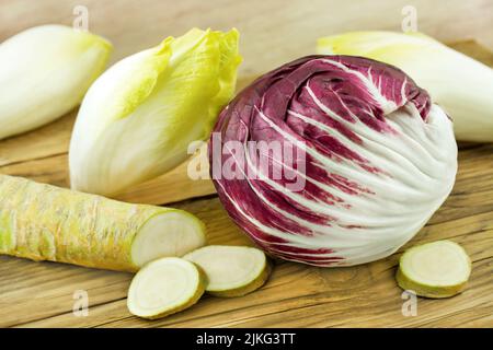 Chicory, horseradish and radicchio on wooden background Stock Photo