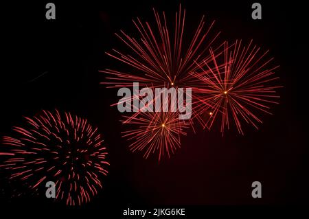 Bright red fireworks explosions filling the sky Stock Photo