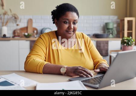 Smiling black young woman doing business while working from home Stock Photo