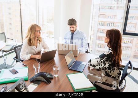 Business meeting at the office. Group of business people sitting around the desk and discussing. Teamwork. Stock Photo