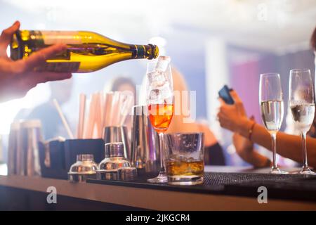 Aperol Spritz Cocktail. Alcoholic beverage based on table with ice cubes and oranges. Stock Photo
