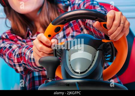 Close-up of gamer woman's hands on console steering wheel Stock Photo