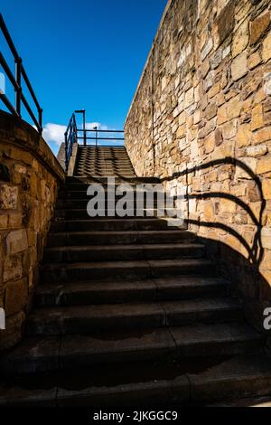 Stairs in shadow leading to a blue sky. Stock Photo