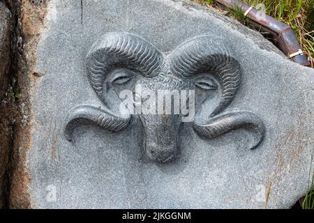 Cows head with large horns carved in rock face in Qaqortoq, Greenland on 13 July 2022 Stock Photo