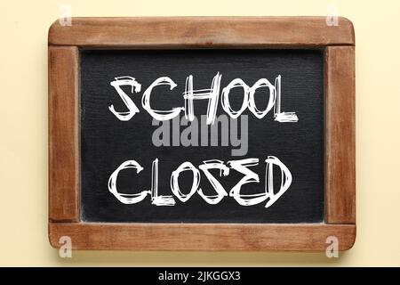 Chalkboard with written text SCHOOL CLOSED on light background Stock Photo