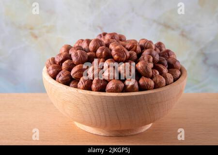 Bowl full of hazelnuts  on wooden background Stock Photo
