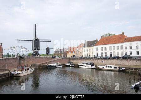 Heusden, Brabant, the Netherlands - May 7, 2022: Drawbridge and windmill at the harbor with boats in a beautiful fortress city Heusden. Stock Photo