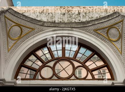 A semi circle window with wooden frame lines in a vintage style building. Stock Photo