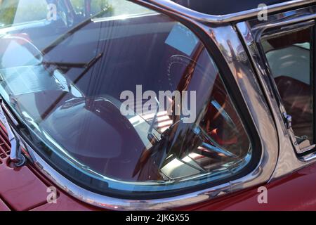 A closeup of a front window of a red classic car Stock Photo