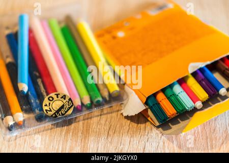 A Closeup of two colored pencil sets on a wooden table Stock Photo