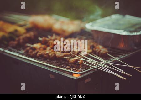 A closeup shot of meat on sticks being barbecued on a brazier Stock Photo