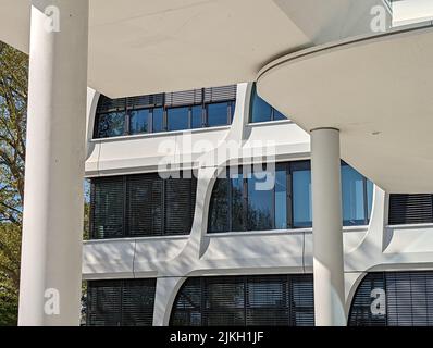 An exterior of a modern white office building with columns and large windows Stock Photo