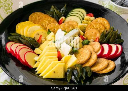A closeup of the plate with various types of cheese and crackers. Stock Photo
