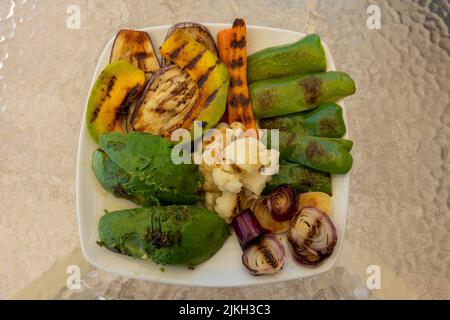 Grilled organic vegetable dish, with pepper, onion, carrot, cauliflower, pumpkin, eggplant and avocado. Healthy and tasty food. Vegetarian food Stock Photo