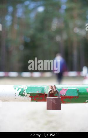 A vertical shot of an old rusty padlock in a blurred background Stock Photo