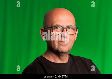 portrait bald man with glasses and green background Stock Photo