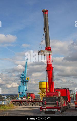 Andernach, Germany - October 25, 2019: a truck crane lifts steel plates on a construction site Stock Photo