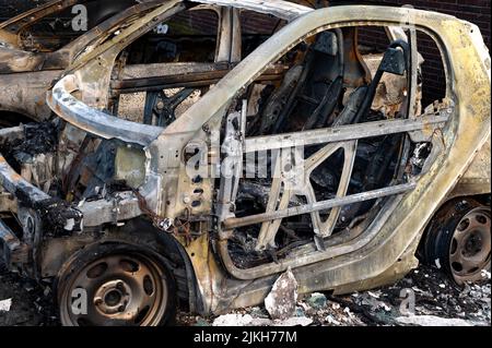 A closeup of burned-up vehicles surrounded by burnt rubble Stock Photo