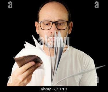 Portrait of a bearded man wearing eyeglasses against a black background. Salvador, Bahia, Brazil. Stock Photo