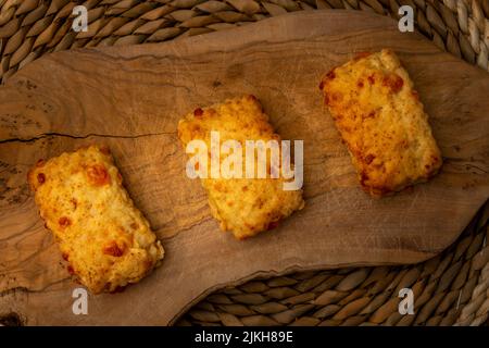 home made cheese  scones  on a wooden chopping board , cooking at home Stock Photo