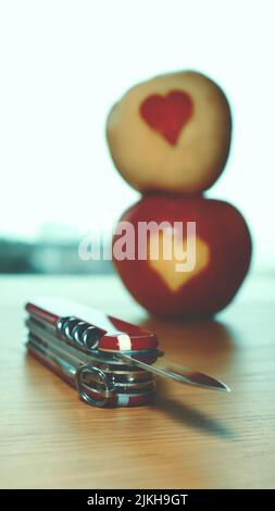A vertical shot of a swiss army knife on a wooden table Stock Photo