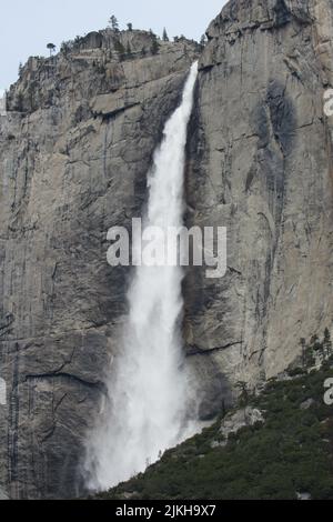 A vertical shot of a beautiful waterfall flowing through the mountains in Yosemite National Park, USA Stock Photo