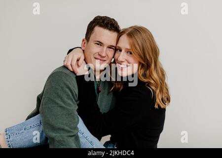 A beautiful Caucasian couple posing for a photo in a studio on a white background Stock Photo