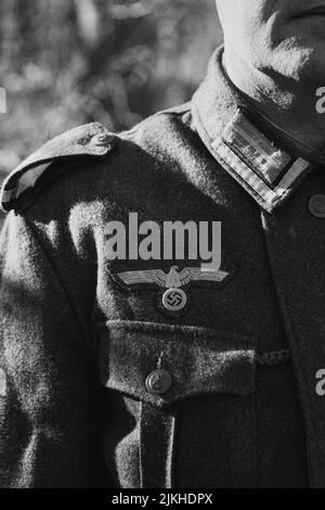 A vertical grayscale shot of a man wearing a German WWII Wehrmacht uniform Stock Photo