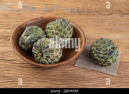 Sugar apples or custard apples in a bowl over wooden table. Stock Photo