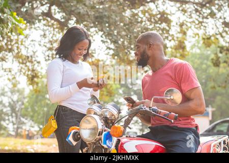 african man and woman sharing content from their phones Stock Photo